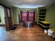 A dining room with olive-green walls, hardwood floors, and natural woodwork at 3179 W 400 N, Fairland, IN 46126
