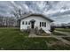 Well-maintained home featuring a side entrance with stairs, a basement access door, and a spacious front lawn at 3179 W 400 N, Fairland, IN 46126