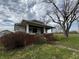 Quaint home featuring a cozy front porch with brick trim and well-maintained landscaping in a serene setting at 3179 W 400 N, Fairland, IN 46126