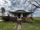 Charming home with a covered front porch and brick accents, surrounded by a green yard and mature trees at 3179 W 400 N, Fairland, IN 46126