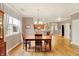 Bright dining room features hardwood floors, chandelier, and natural light from the window, with a view of the kitchen at 3447 Heathcliff Ct, Westfield, IN 46074