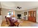 Cozy living room boasts hardwood floors, neutral walls, ceiling fan, TV, area rug and view to sunroom at 3447 Heathcliff Ct, Westfield, IN 46074