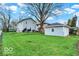 Spacious backyard featuring the home's exterior and a detached garage with light blue siding at 3601 Carrollton Ave, Indianapolis, IN 46205