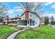 Two-story home with screened-in porch, brick chimney, and a well-maintained lawn at 3601 Carrollton Ave, Indianapolis, IN 46205