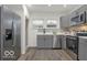 Modern kitchen with stainless steel appliances, gray cabinets, and bright windows at 3601 Carrollton Ave, Indianapolis, IN 46205