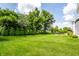 Expansive backyard with lush green lawn, mature trees, fire pit, and patio furniture, creating an ideal outdoor space at 3641 Shady Lake Dr, Westfield, IN 46074