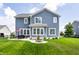 Rear exterior view of a two-story home with a well-manicured lawn, fire pit, and patio area perfect for entertaining at 3641 Shady Lake Dr, Westfield, IN 46074