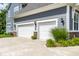 Three-car garage with white doors and stone accents, complementing the home's exterior and landscaping at 3641 Shady Lake Dr, Westfield, IN 46074