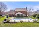 Large brick home with an in-ground pool, covered patio, and landscaped backyard at 3976 Bent Tree Ln, Greenwood, IN 46143