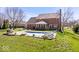 Spacious backyard featuring a brick home, covered patio, in-ground pool, and green lawn at 3976 Bent Tree Ln, Greenwood, IN 46143