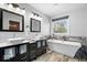 This bathroom features a drop in bathtub, dual sinks, and modern fixtures at 3976 Bent Tree Ln, Greenwood, IN 46143
