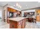Bright kitchen with a large center island, granite countertops, and wood cabinets open to living area at 3976 Bent Tree Ln, Greenwood, IN 46143