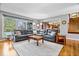 Open living room area with a large sectional sofa, hardwood floors, and access to the kitchen and sunroom at 3976 Bent Tree Ln, Greenwood, IN 46143
