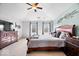 This bright main bedroom features a tray ceiling, a ceiling fan, and windows with exterior views at 3976 Bent Tree Ln, Greenwood, IN 46143