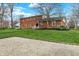 View of the backyard featuring a brick exterior, lush grass, and mature trees at 40 Twinshore Ct, Carmel, IN 46033