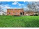 Expansive backyard featuring a brick exterior, lush grass, and outdoor patio at 40 Twinshore Ct, Carmel, IN 46033