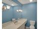 Powder blue bathroom featuring a large mirror, a cream sink, and traditional wall sconces at 40 Twinshore Ct, Carmel, IN 46033