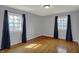 Bright bedroom featuring hardwood floors, light gray walls, and windows with dark curtains at 40 Twinshore Ct, Carmel, IN 46033