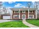 Charming two-story brick home boasts a welcoming front porch with elegant white columns at 40 Twinshore Ct, Carmel, IN 46033