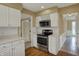 Well-lit kitchen features white cabinets, countertops, stainless steel oven, and hardwood floors at 40 Twinshore Ct, Carmel, IN 46033