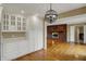 The kitchen has white storage cabinets, counters and wood flooring near a brick fireplace at 40 Twinshore Ct, Carmel, IN 46033