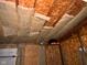 View of unfinished basement ceiling with insulation, wood and exposed structure at 413 W 8Th St, Muncie, IN 47302