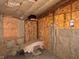 View of unfinished basement with insulation, wood, shelving, and exposed structure at 413 W 8Th St, Muncie, IN 47302