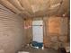 Unfinished basement featuring exposed insulation, a door, and miscellaneous items at 413 W 8Th St, Muncie, IN 47302