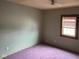 Bedroom featuring purple carpet, green walls and a window with blinds at 413 W 8Th St, Muncie, IN 47302