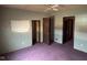 Bedroom with three doorways, ceiling fan, and purple carpet at 413 W 8Th St, Muncie, IN 47302