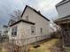 Side view of the two-story home with vinyl siding, framed windows, and a chain link fence at 413 W 8Th St, Muncie, IN 47302