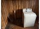 This laundry area features wood paneling and a white laundry machine at 413 W 8Th St, Muncie, IN 47302
