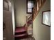 Stairwell featuring carpeted steps, wooden banister and railing, and a window with blinds at 413 W 8Th St, Muncie, IN 47302