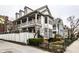 Charming multi-story home boasts a covered porch, well-manicured landscaping, and fenced yard at 424 E Vermont St, Indianapolis, IN 46202