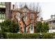 Charming red brick home with lush landscaping, providing shade and privacy in the front yard at 424 E Vermont St, Indianapolis, IN 46202