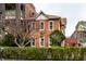 Charming red brick house with white trim, surrounded by lush green hedges and a tree at 424 E Vermont St, Indianapolis, IN 46202