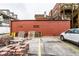 A walled-in parking lot shows an accumulation of discarded materials beside parked vehicles at 424 E Vermont St, Indianapolis, IN 46202