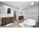 Spacious bathroom with dual wood vanities, freestanding tub, and wood grain tile floor at 4915 E 79Th St, Indianapolis, IN 46250