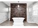 Bathroom with freestanding tub with wood accent wall and marble tiled walls at 4915 E 79Th St, Indianapolis, IN 46250
