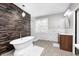 Bright bathroom featuring a freestanding tub, wood accent wall, and marble tiled backsplash at 4915 E 79Th St, Indianapolis, IN 46250