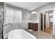 Bathroom with a freestanding tub, wood grain tile floor, and wooden vanity at 4915 E 79Th St, Indianapolis, IN 46250