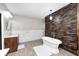 Bright bathroom featuring a freestanding tub, wood accent wall, and marble tiled backsplash at 4915 E 79Th St, Indianapolis, IN 46250