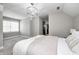 A well-lit bedroom offers gray walls, carpet flooring, plus a window, and a modern chandelier at 4915 E 79Th St, Indianapolis, IN 46250