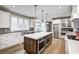 Modern kitchen with white cabinets, a large island, stainless steel appliances, and hardwood floors at 4915 E 79Th St, Indianapolis, IN 46250