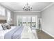 Bright main bedroom featuring a large bed, chandelier, and sliding glass doors at 4915 E 79Th St, Indianapolis, IN 46250