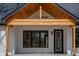 Close up of a covered porch featuring wood ceiling, black trim windows, and concrete base at 5123 Oak Ridge Pl, Columbus, IN 47201