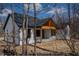 Newly built house with white siding, a black roof, and a wooden covered porch at 5123 Oak Ridge Pl, Columbus, IN 47201
