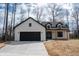New construction modern farmhouse featuring a black garage door and coordinating window trim at 5123 Oak Ridge Pl, Columbus, IN 47201