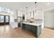 Modern kitchen with white cabinets, a green island, stainless steel appliances, and wood-look tile floors at 5123 Oak Ridge Pl, Columbus, IN 47201