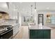 Bright, open kitchen featuring a large island with a sink, stainless steel appliances, and elegant white cabinetry at 5123 Oak Ridge Pl, Columbus, IN 47201